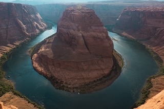 Photography by Keagen Thomson of Horseshoe bend Arizona, a winding river in an orange canyon in the sunny afternoon