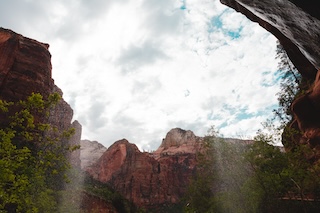 Photography by Keagen Thomson of Zion Canyon Utah, a canyon view against the sky from beneath a waterfall 